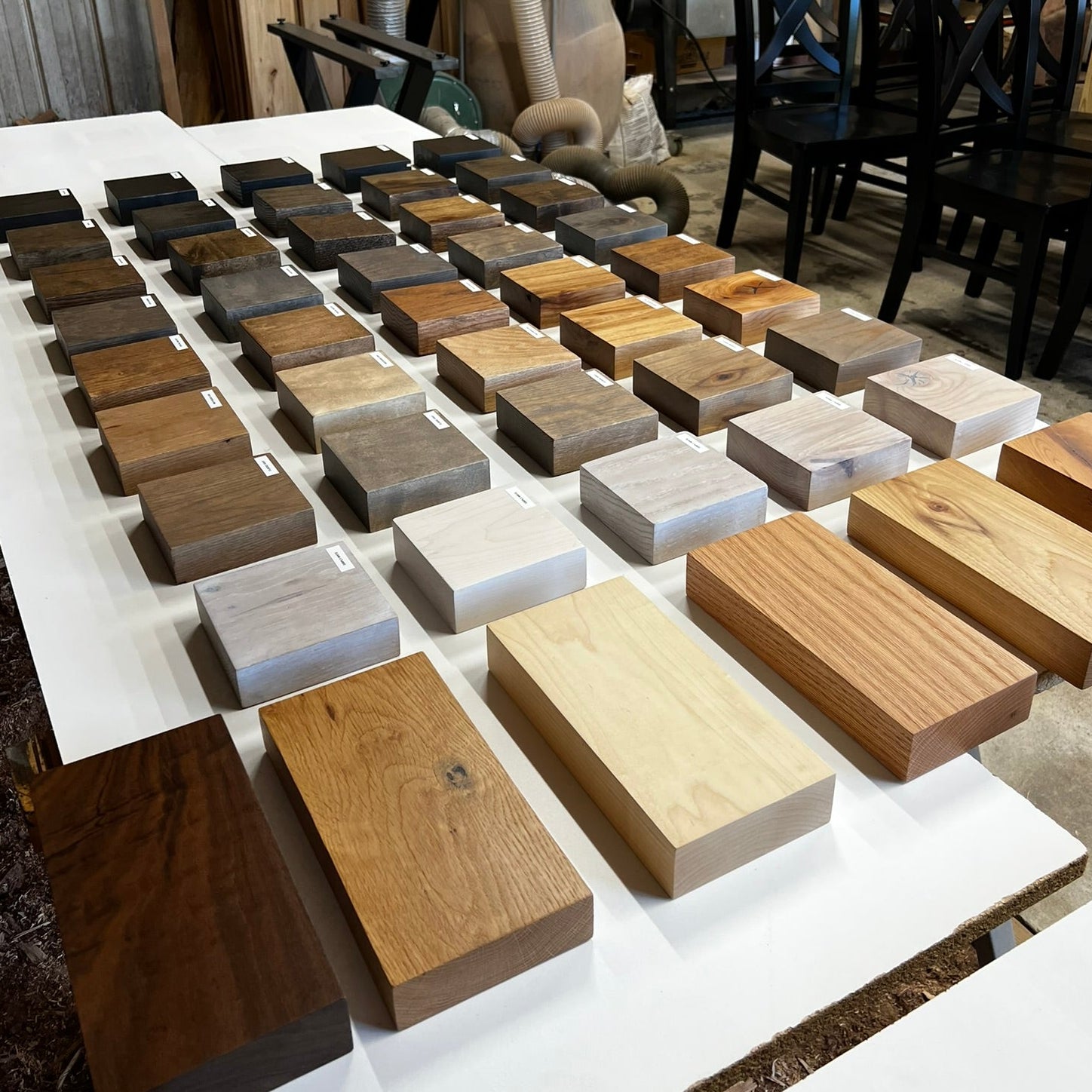 Wood sample blocks arranged on a table with a workshop background